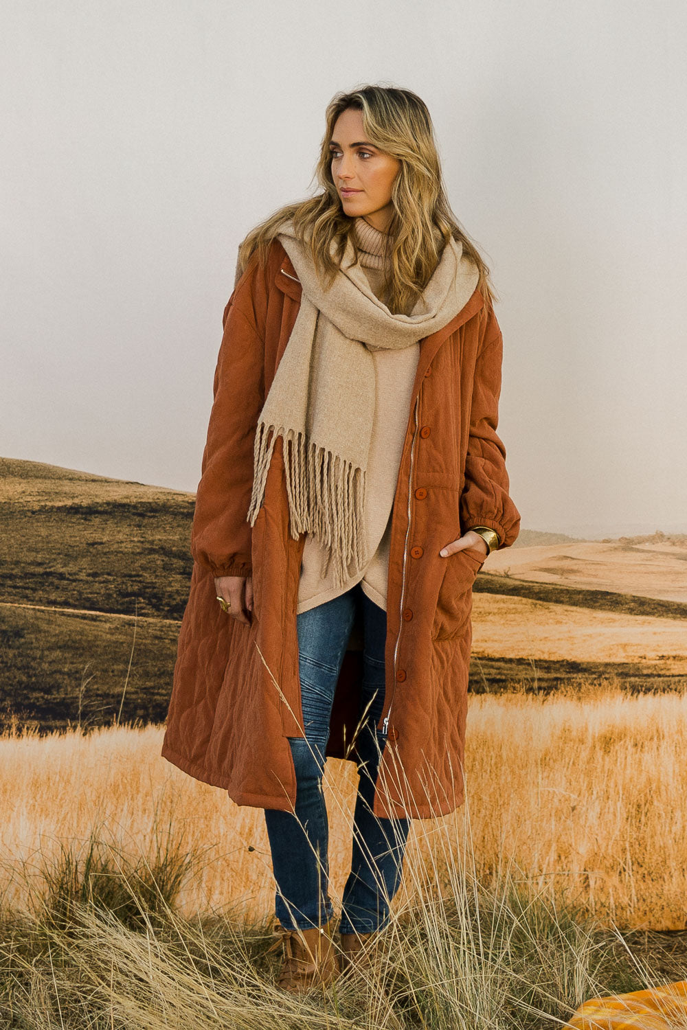 Model Tegan wearing size 10 of the Heart Warming Quilted Anorak in colour Rust, from the front, showing the whole outfit