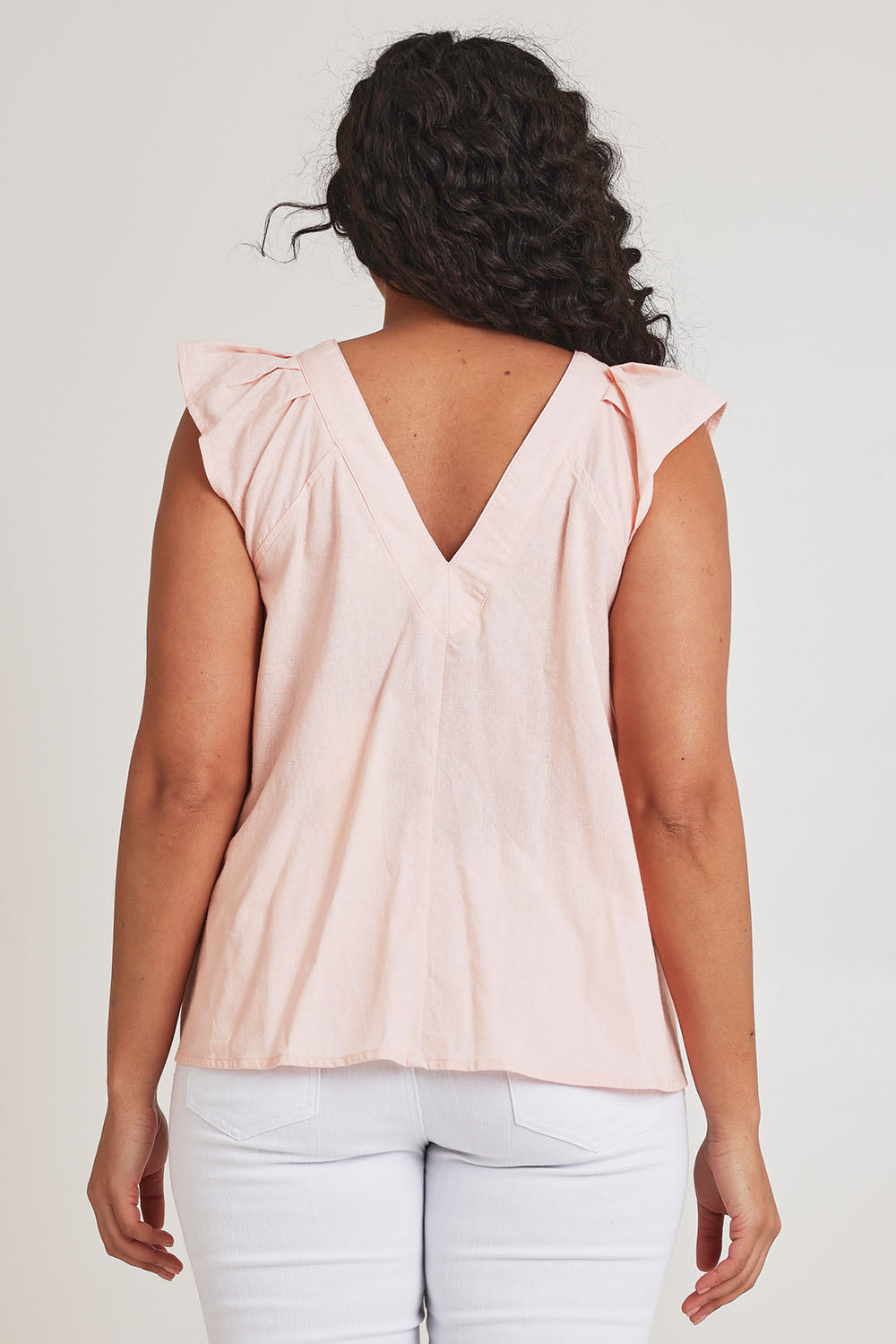 Model Terri-Leigh wearing size 14 of the Frill Me Cotton Top in colour Petal (Pink), from the back