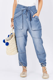 Model Georgia wearing size 10 of the With My Tribe Pants in colour Denim (Blue), from the front, cropped image