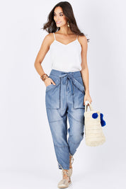 Model Georgia wearing size 10 of the With My Tribe Pants in colour Denim (Blue), from the front, showing the whole outfit