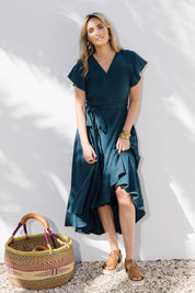 Model Tegan wearing size 10 of the Thats A Wrap Organic Cotton Dress in colour Lagoon (Blue), from the front, showing the whole outfit