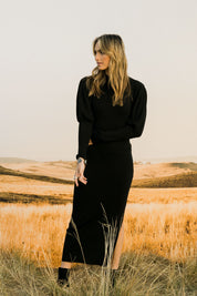 Model Tegan wearing size S of the Day Or Night Balloon Sleeve Dress in colour Black (Black), from the front, showing the whole outfit