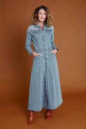 Model Emma wearing size 10 of the Calamity Denim Maxi Dress in colour Denim (Blue), from the front, showing the whole outfit