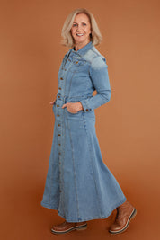 Model Sandy wearing size 10 of the Calamity Denim Maxi Dress in colour Denim (Blue), from the front, showing the whole outfit