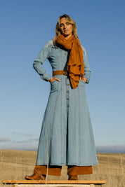 Model Tegan wearing size 10 of the Calamity Denim Maxi Dress in colour Denim (Blue), from the front, showing the whole outfit