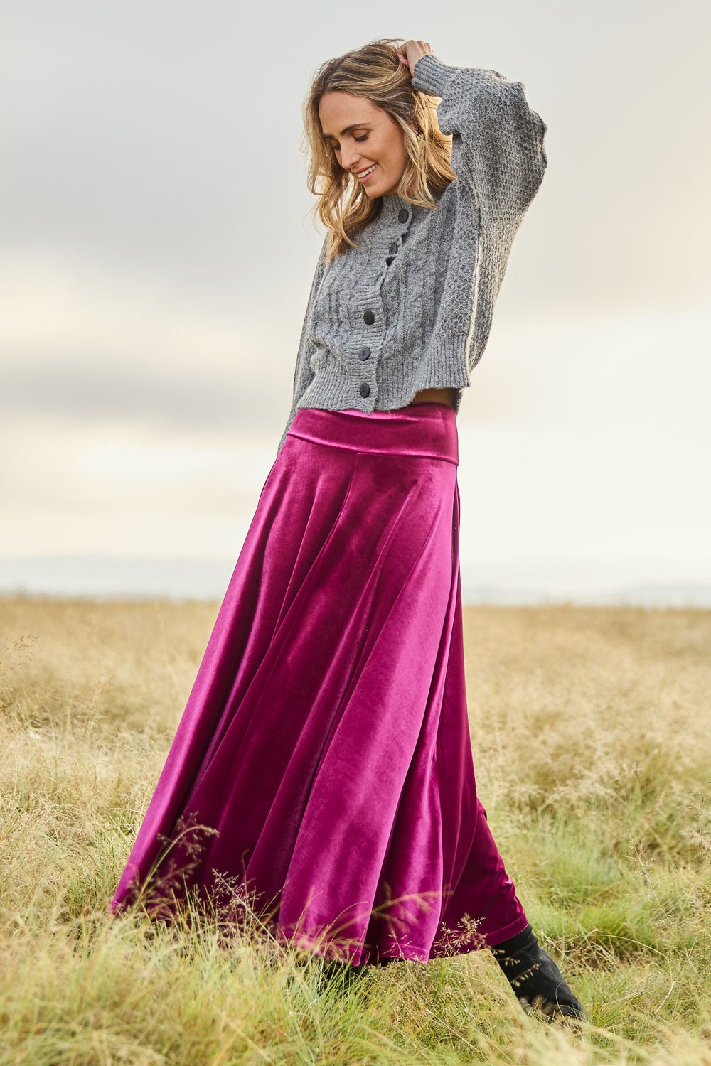 Model Tegan wearing size 10 of the Love By Candlelight Velvet Skirt in colour Mulberry (Pink), from the front, showing the whole outfit