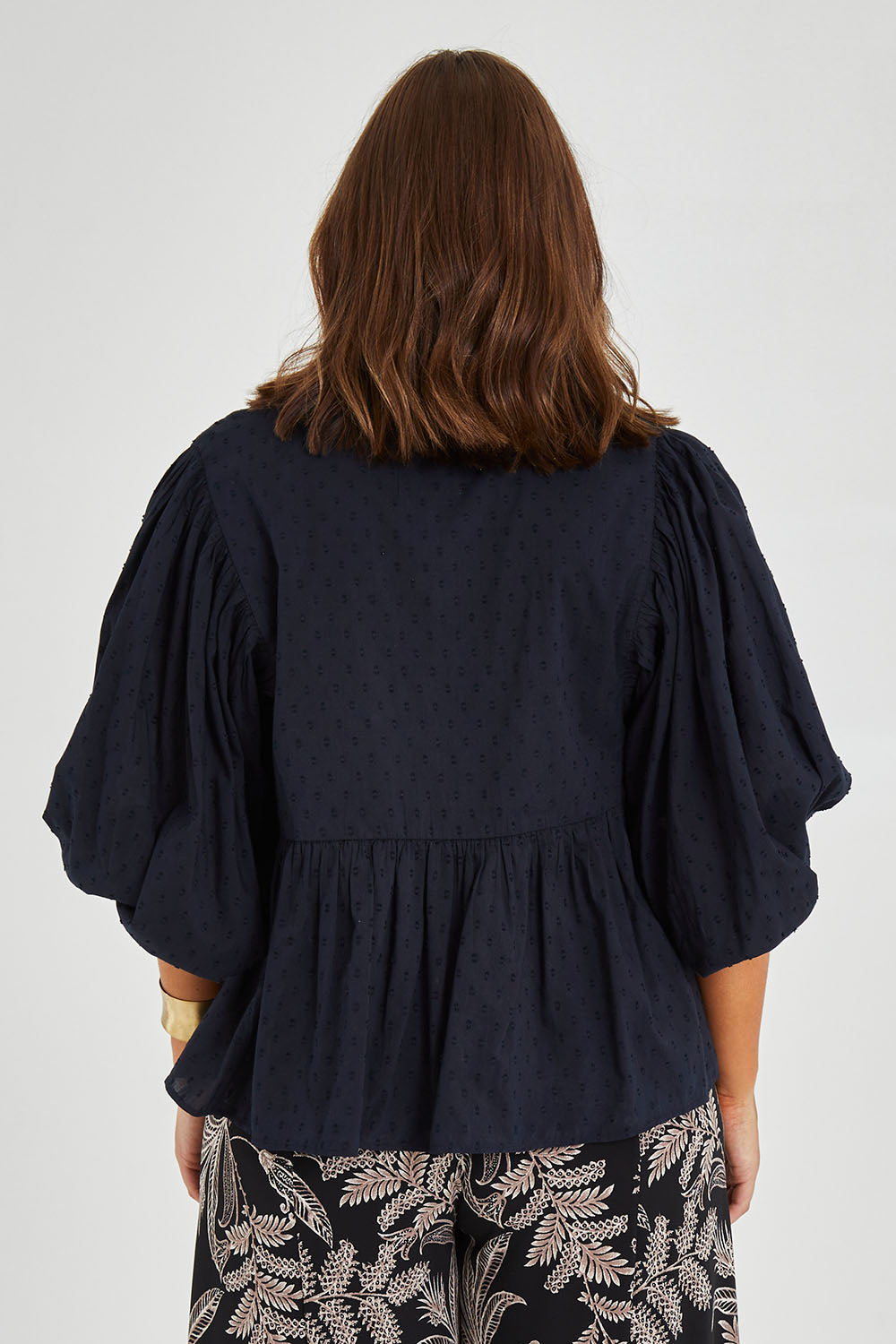 Model Monique wearing size 14 of the Happy Hour Dobby Blouse in colour Black (Black), from the back