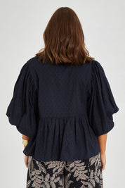 Model Monique wearing size 14 of the Happy Hour Dobby Blouse in colour Black (Black), from the back