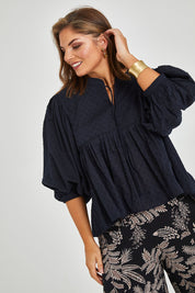 Model Monique wearing size 14 of the Happy Hour Dobby Blouse in colour Black (Black), from the front, cropped image