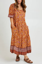 Model Laura wearing size 14 of the Paradise Found Maxi Dress in colour Rustfleur, from the front, cropped image