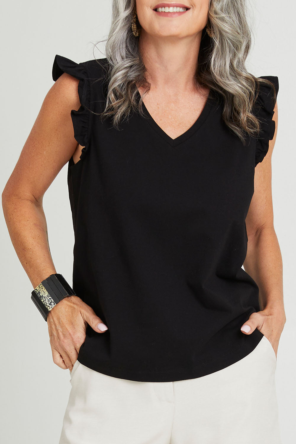 Model Luisa wearing size 10 of the For The Frill Of It Tee in colour Black (Black), from the front, cropped image