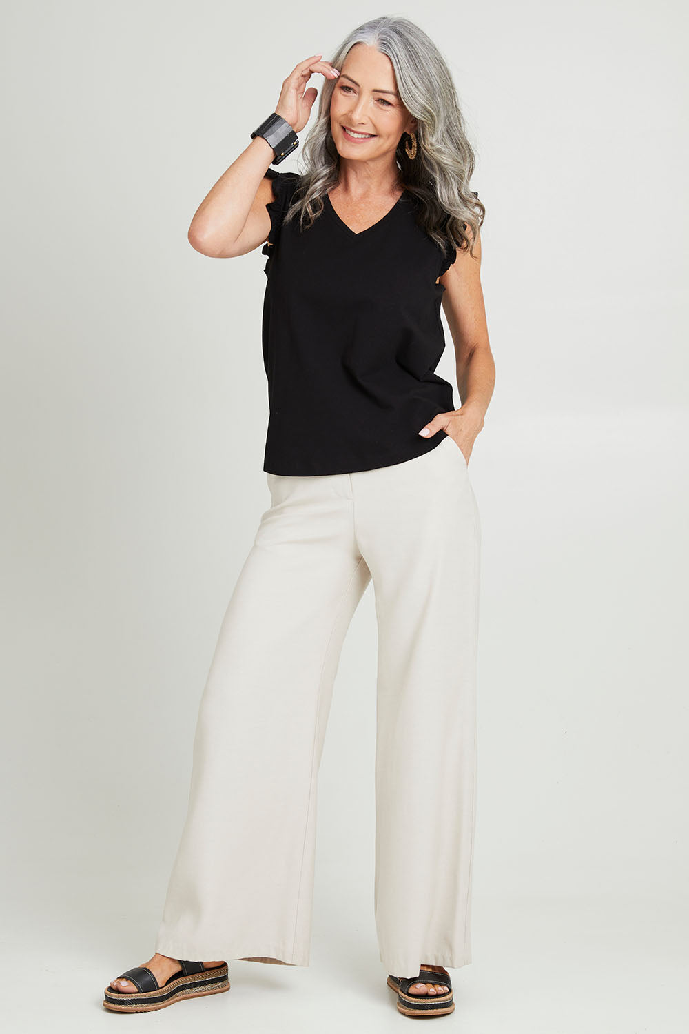 Model Luisa wearing size 10 of the For The Frill Of It Tee in colour Black (Black), from the front, showing the whole outfit