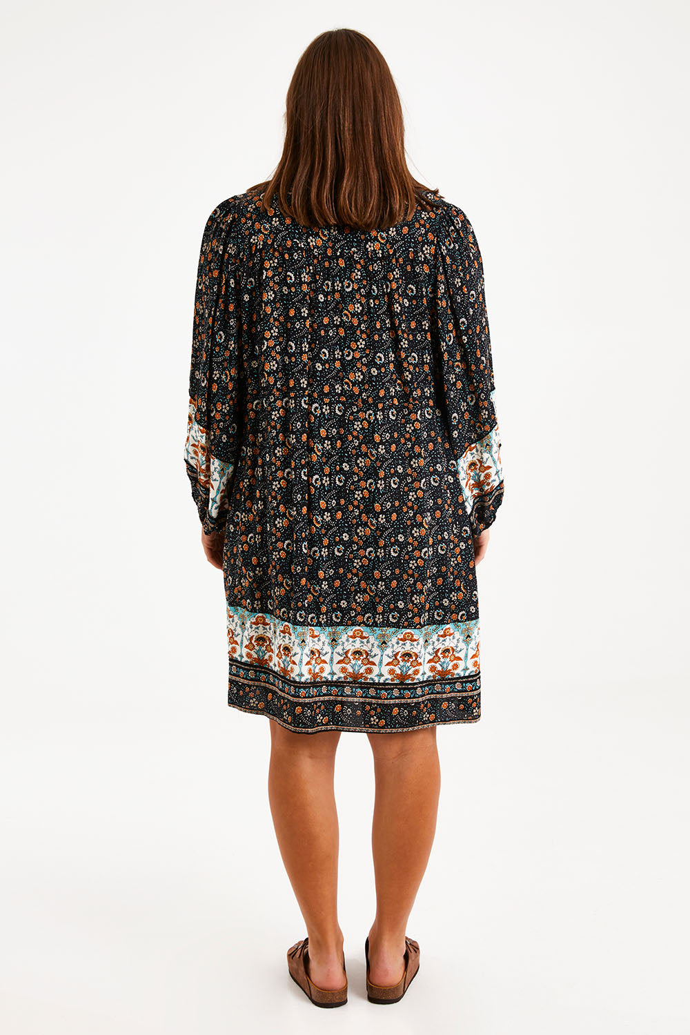 Model Monique wearing size 14 of the Sunset Dreamer Dress in colour Blkfleur (Black), from the back