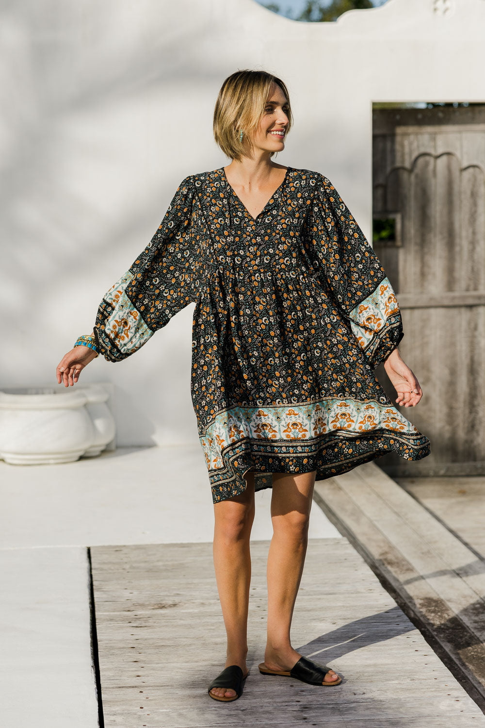 Model Tegan wearing size 10 of the Sunset Dreamer Dress in colour Blkfleur (Black), from the front, showing the whole outfit
