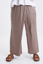 Model Monique wearing size 14 of the Going With The Flow Overlay Pants in colour Bungee, from the front, cropped image