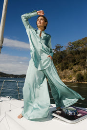 Model Tegan wearing size 10 of the Going With The Flow Wide Leg Pants in colour Sage (Green), from the front, showing the whole outfit
