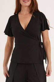 Model Sally wearing size 10 of the All For You Wrap Top in colour Black (Black), from the front, cropped image
