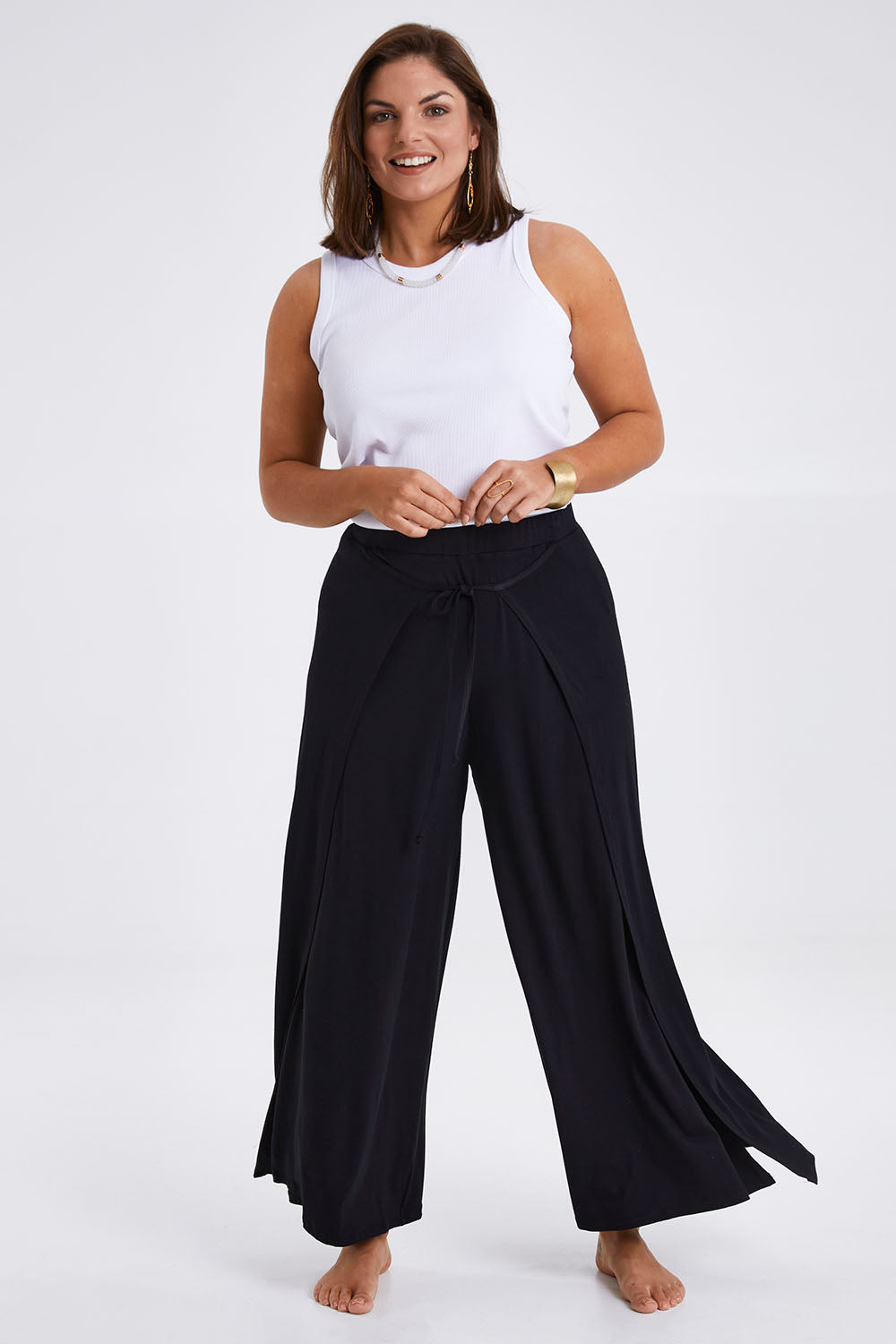 Model Monique wearing size 14 of the All For You Wrap Pants in colour Black (Black), from the front, showing the whole outfit