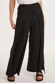 Model Sally wearing size 10 of the All For You Wrap Pants in colour Black (Black), from the front, cropped image