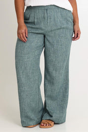 Model Ashleigh wearing size 16 of the Blazing Trails Pants in colour Duskgreen (Green), from the front, cropped image