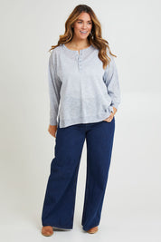 Model Laura wearing size L of the Go To Knit Boyfriend Henley in colour Sky (Blue), from the front, showing the whole outfit