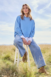 Model Tegan wearing size S of the Have You Seam Me Cotton Cashmere Jumper in colour Bluebird (Blue), from the front, showing the whole outfit