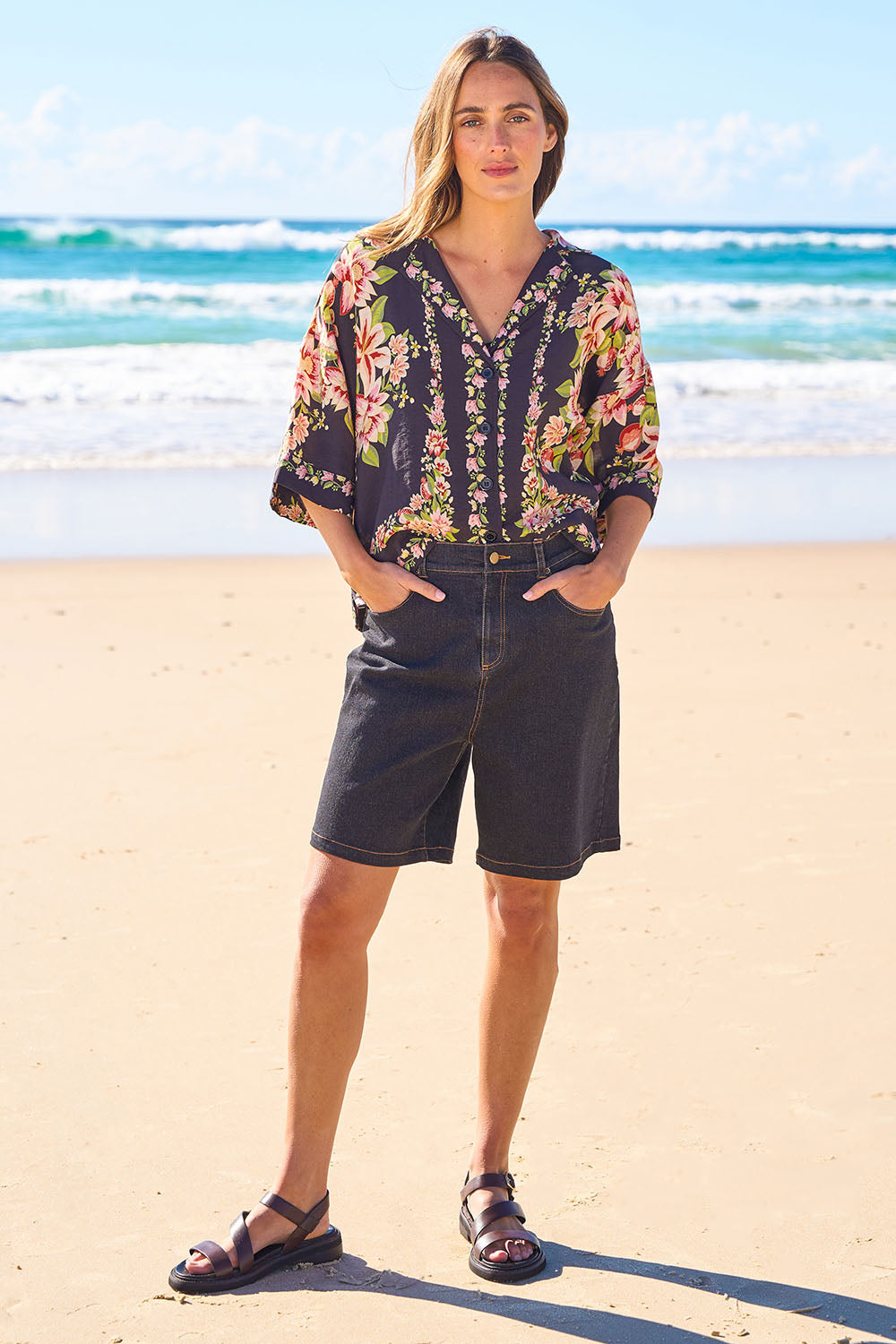 Model Tegan wearing size 10 of the Daily Dose Longline Denim Shorts in colour Black (Black), from the front, showing the whole outfit