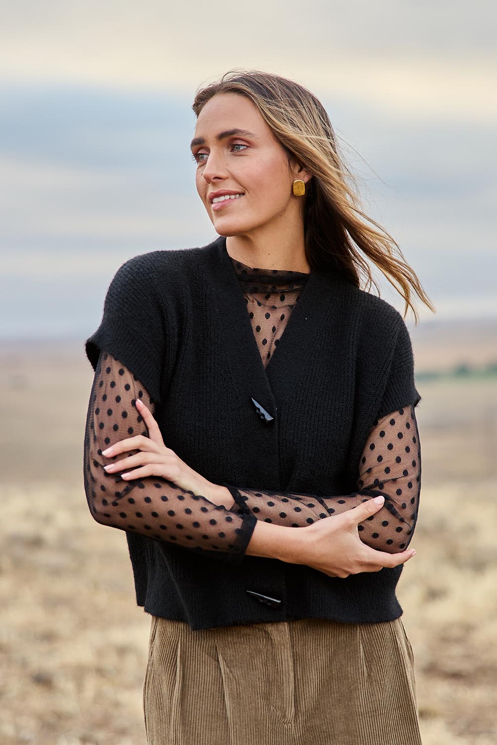 Model Tegan wearing size S of the Found My Friend Recycled Knit Sleeveless Cardi in colour Black (Black), from the front, showing the whole outfit
