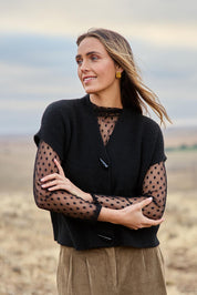 Model Tegan wearing size S of the Found My Friend Recycled Knit Sleeveless Cardi in colour Black (Black), from the front, showing the whole outfit