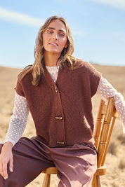 Model Tegan wearing size S of the Found My Friend Recycled Knit Sleeveless Cardi in colour Copper, from the front, showing the whole outfit