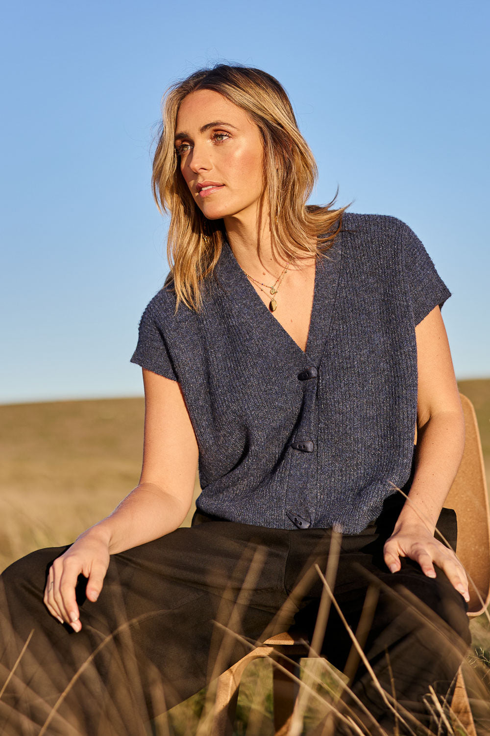 Model Tegan wearing size S of the Found My Friend Recycled Knit Sleeveless Cardi in colour Denim (Blue), from the front, showing the whole outfit
