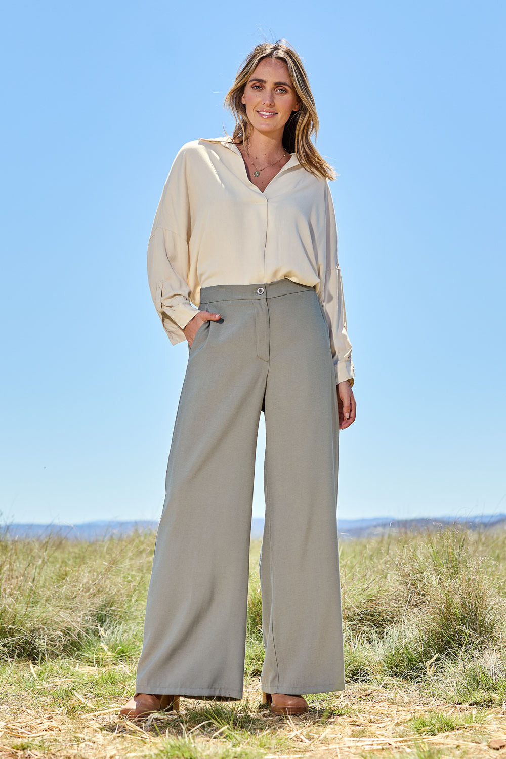Model Tegan wearing size 10 of the Easy Does It Popover Shirt in colour Latte, from the front, showing the whole outfit