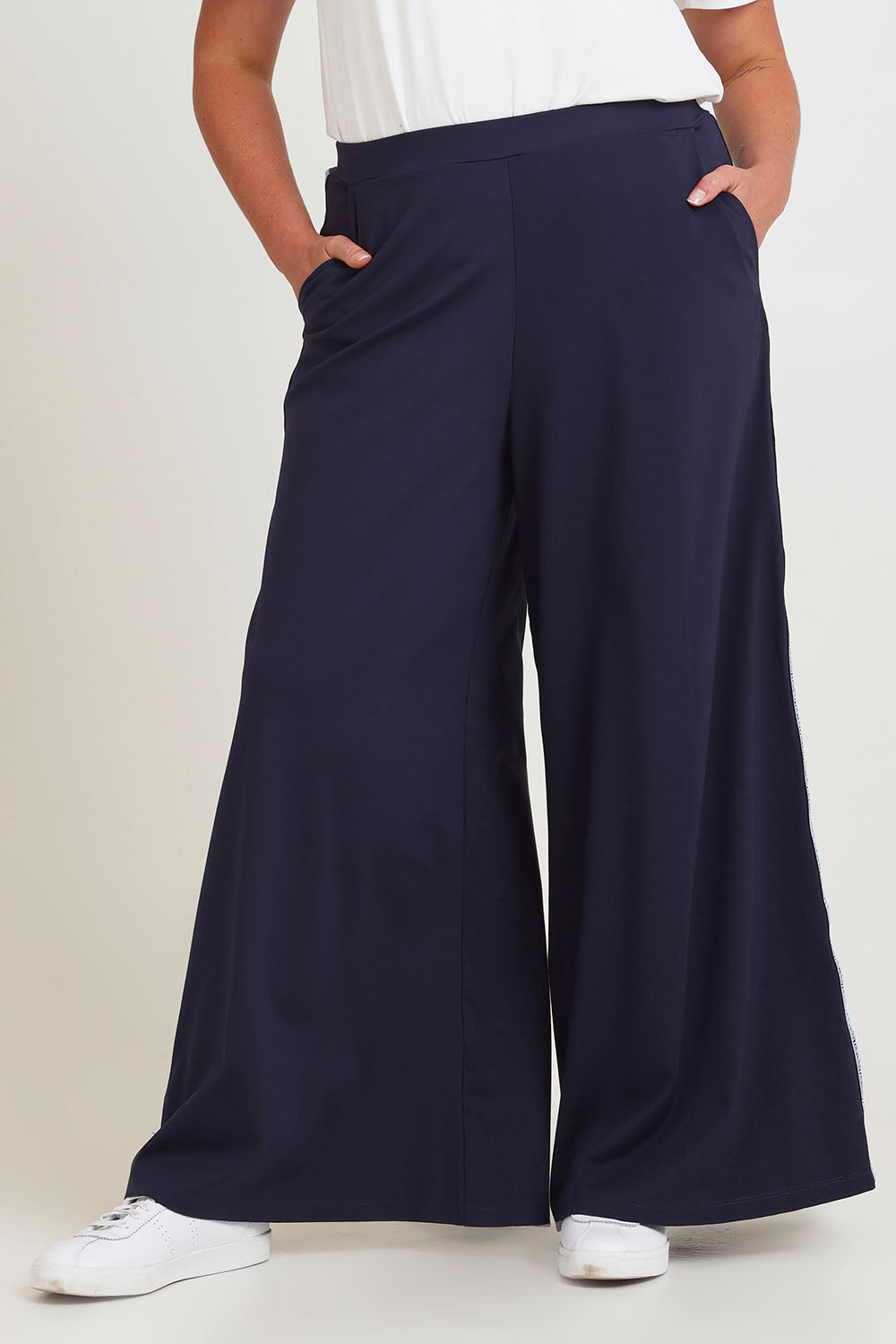 Model Chanel wearing size 16 of the Follow My Lead Side Stripe Pants in colour Navy (Blue), from the front, cropped image