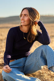 Model Tegan wearing size S of the Love Layer Long Sleeve Knit Top in colour Navy (Blue), from the front, showing the whole outfit