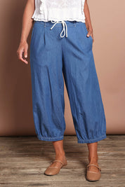 Model Riina wearing size 10 of the Summer Daze Denim Pull On 3/4 Pant in colour Denim (Blue), from the front, cropped image
