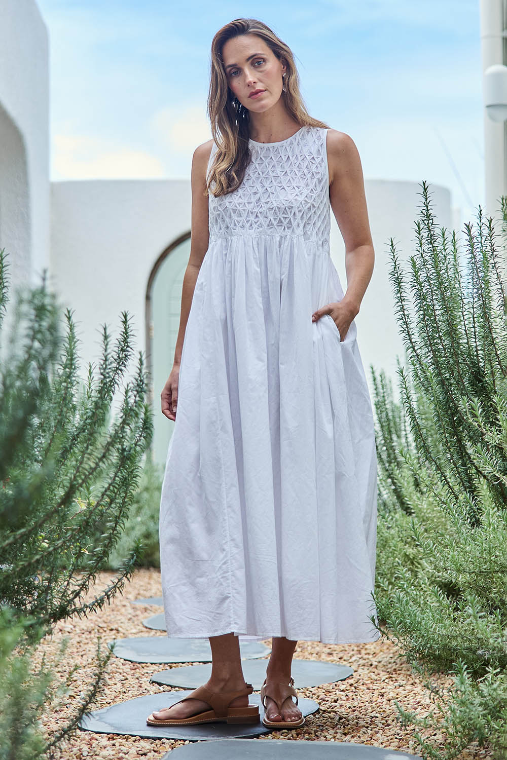 Model Tegand wearing size 10 of the Summer Breeze Smocked Cotton Dress – White in colour White, from the front