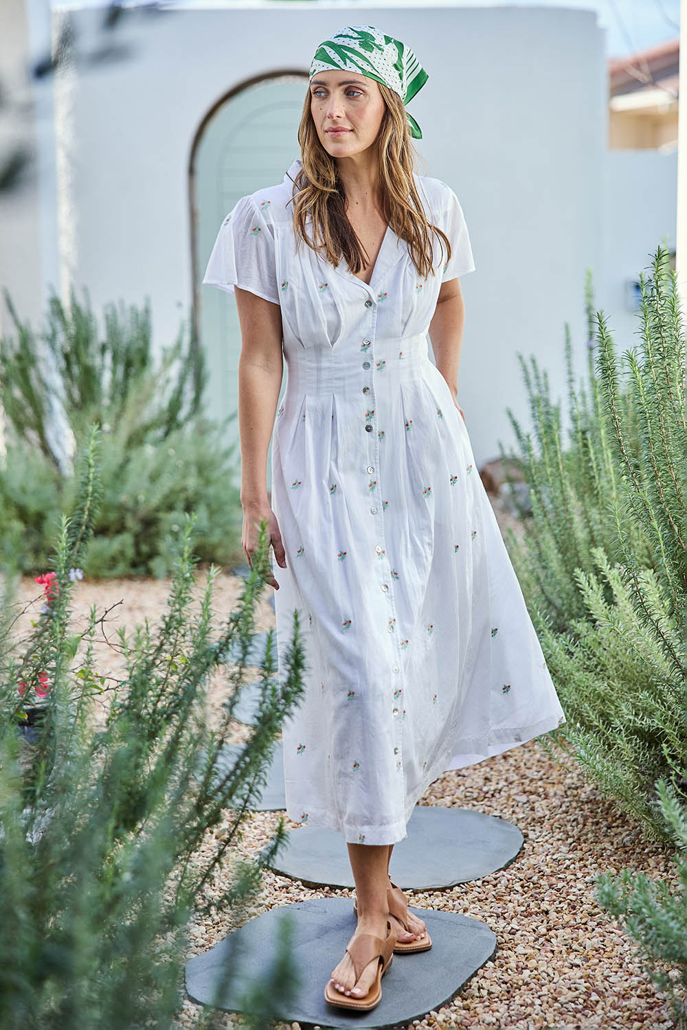 Model Tegand wearing size 10 of the Flower Field Cotton Embroidered Dress – White in colour White, from the front