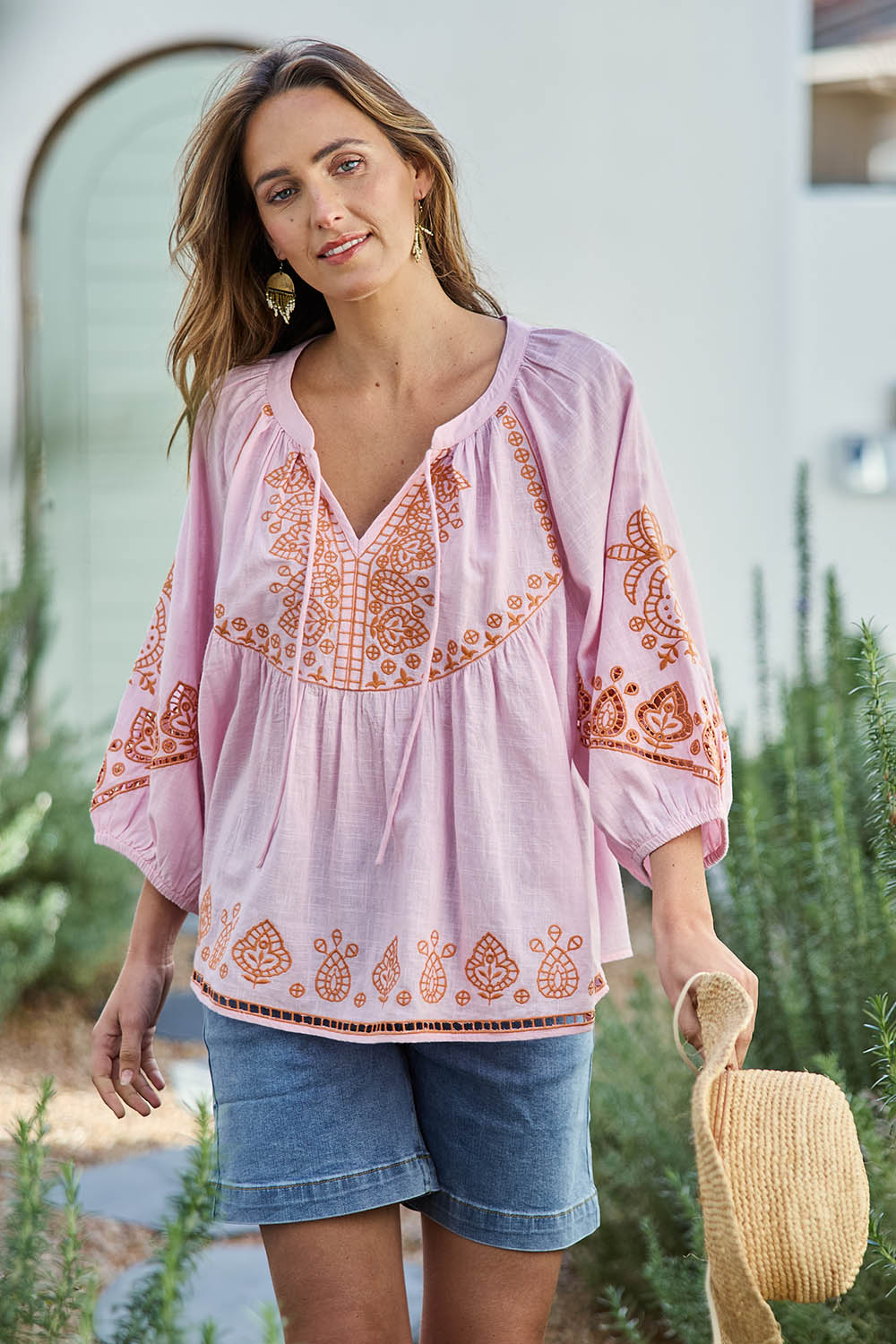Model Tegand wearing size 10 of the Loving You Is Easy Embroidered Cotton Blouse  - Pinktangerine in colour Pinktangerine, in a cropped view
