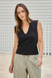 Model Tegand wearing size 10 of the Sweet Intentions Deep V Neck Tank – Black in colour Black, in a cropped view