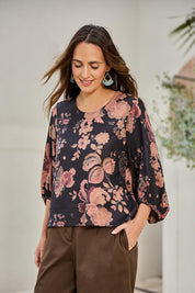 Model Tegand wearing size 10 of the Flowers For Me Balloon Sleeve Top – Blackfleur in colour Blackfleur, from an angle