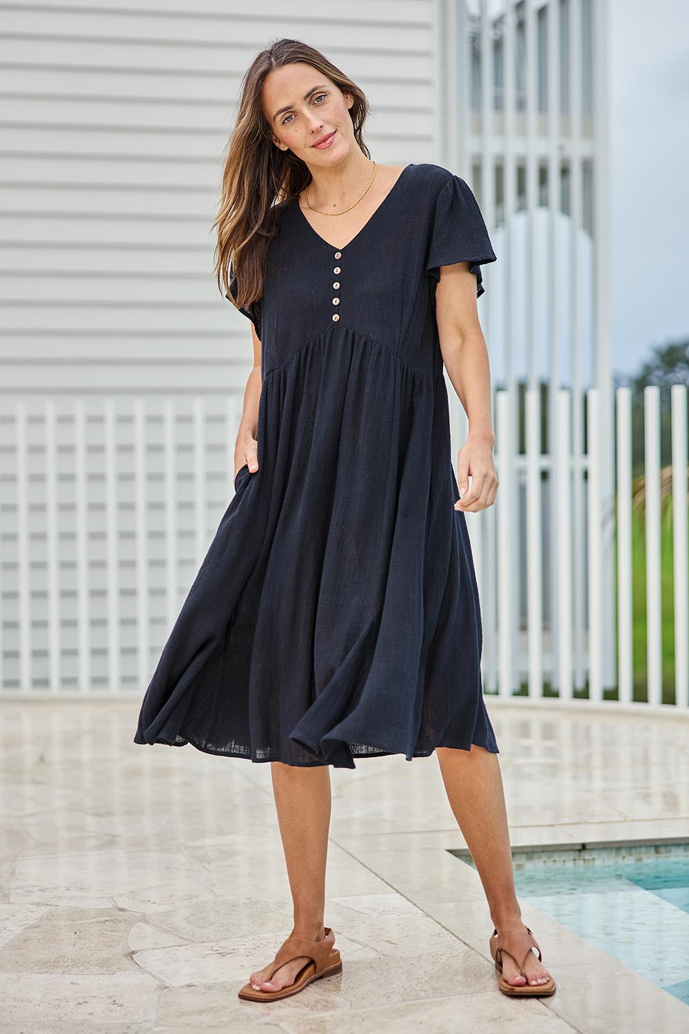Model Tegand wearing size 10 of the Cute As A Button Cotton Midi Dress – Black in colour Black, from the front