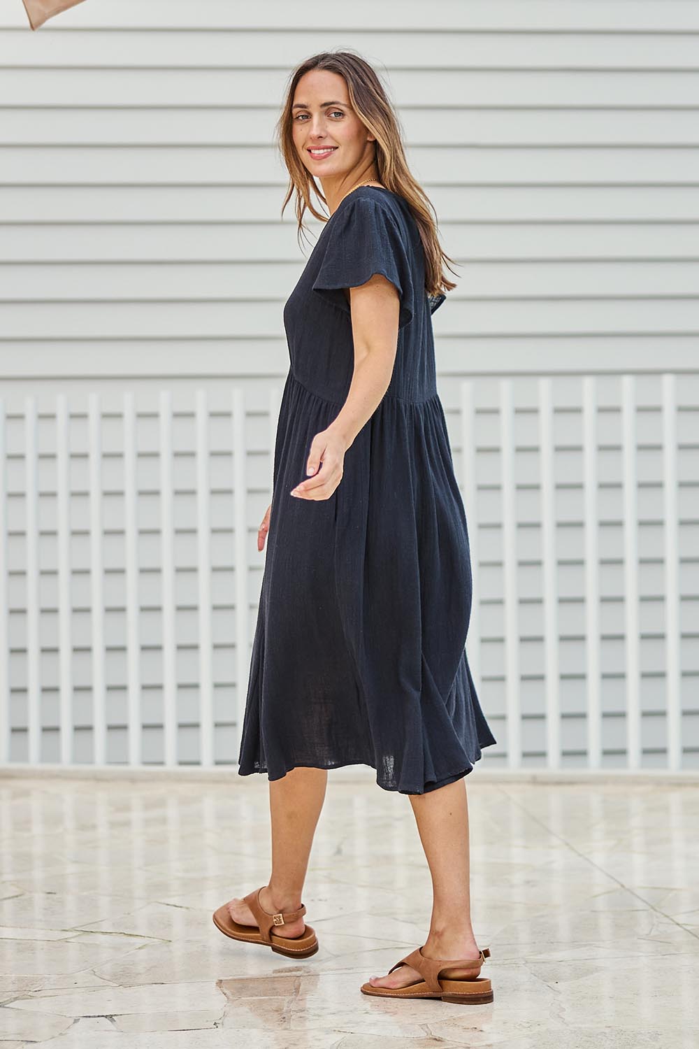 Model Tegand wearing size 10 of the Cute As A Button Cotton Midi Dress – Black in colour Black, from the front