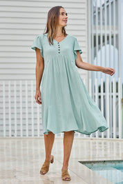 Model Tegand wearing size 10 of the Cute As A Button Cotton Midi Dress – Sage in colour Sage, from the front
