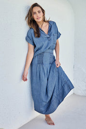 Model Tegand wearing size 10 of the Perfect Day Pleat Detail Lyocell Maxi Skirt – Denim in colour Denim, from the front
