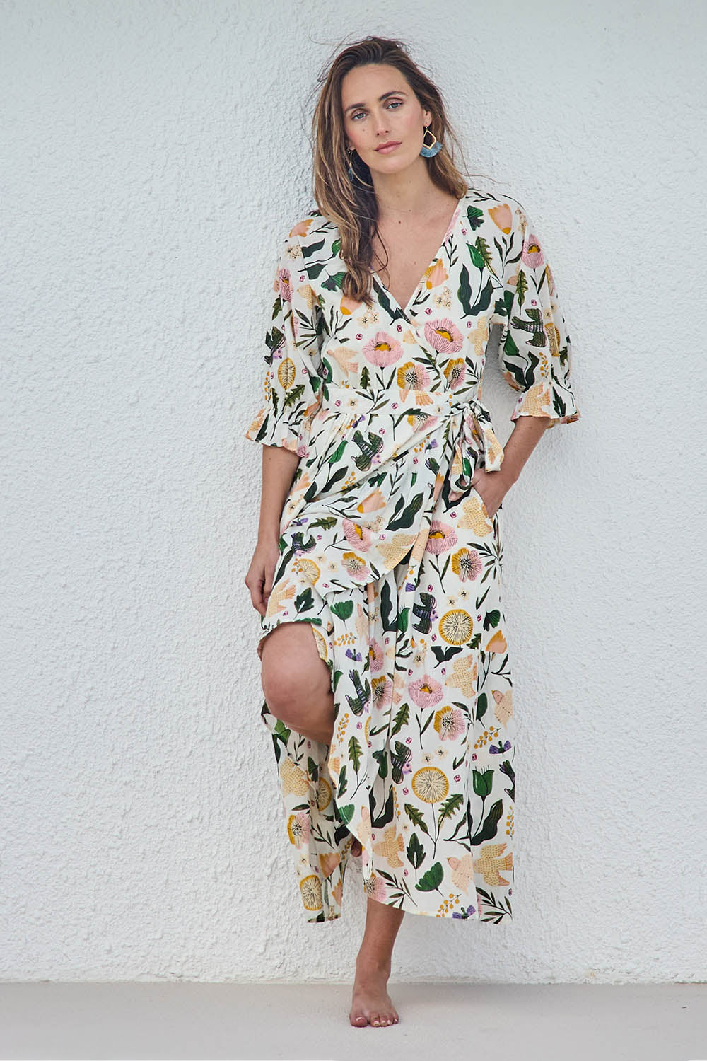 Model Tegand wearing size 10 of the Frill of Birds Cotton Wrap Dress - Birdfleur in colour Birdfleur, from the front