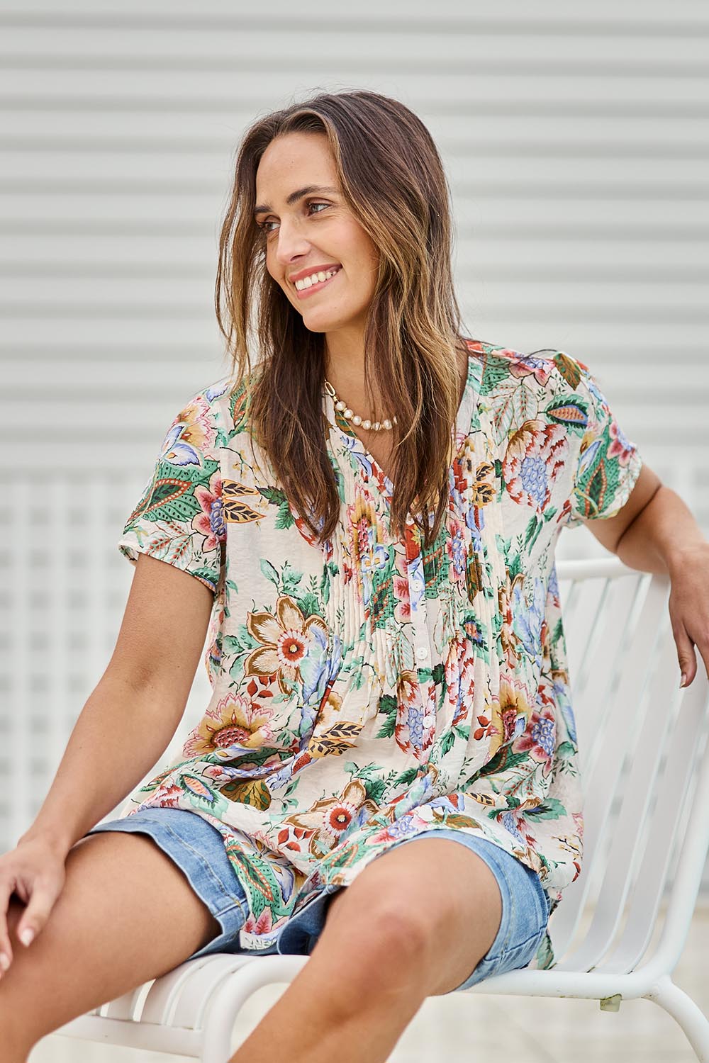Model Tegand wearing size 10 of the Sunny Day Pleated Short Sleeve Blouse – Fleur in colour Fleur, in a cropped view