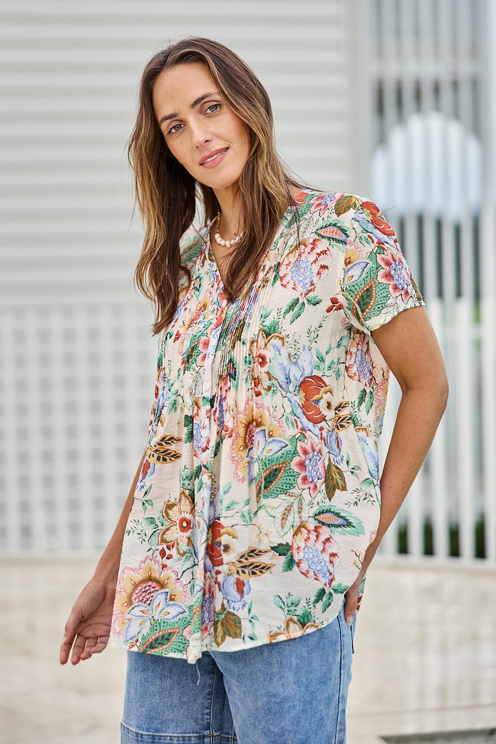 Model Tegand wearing size 10 of the Sunny Day Pleated Short Sleeve Blouse – Fleur in colour Fleur, in a cropped view