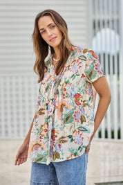 Model Tegand wearing size 10 of the Sunny Day Pleated Short Sleeve Blouse – Fleur in colour Fleur, in a cropped view