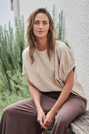 Model Tegand wearing size 10 of the Sun Gazer Balloon Sleeve Top – Sand in colour Sand, in a cropped view