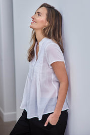 Model Tegand wearing size 10 of the Pleated Delight Cotton Blouse – White in colour White, from an angle